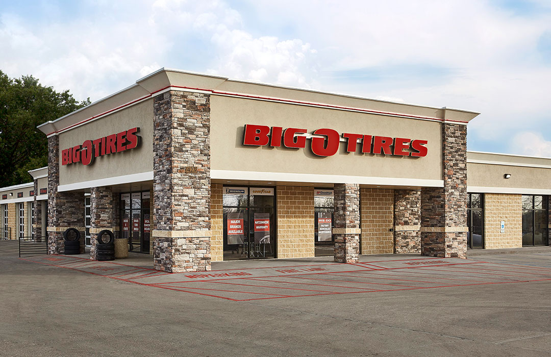 A big tire store in a parking lot.