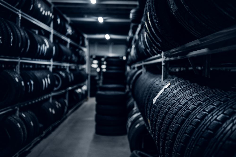 A black and white image of tires in a warehouse at an automotive franchise.