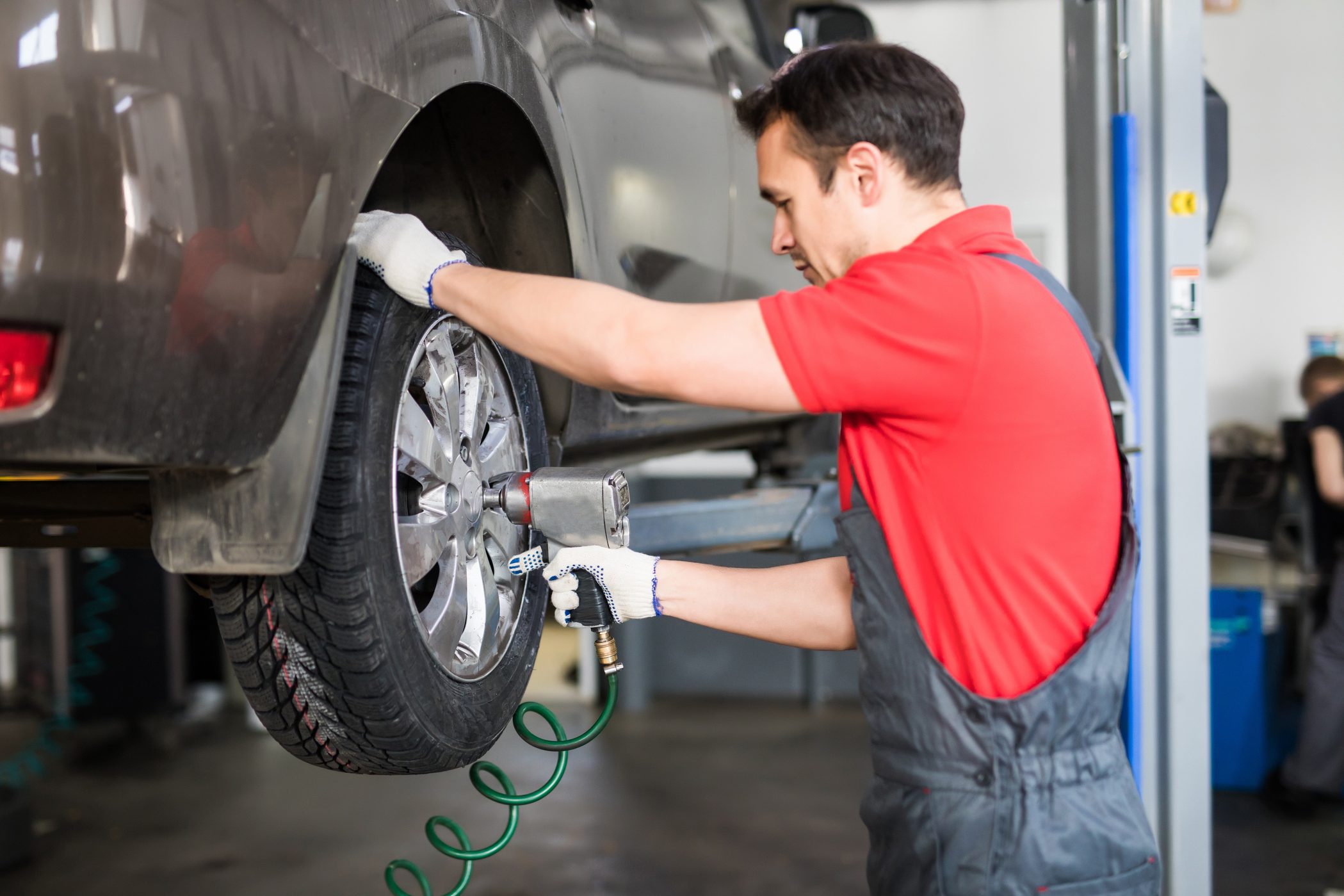 A mechanic is working on a tire at an automotive franchise.