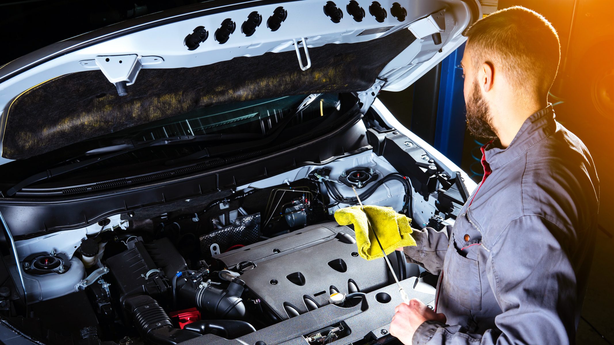 Upscale automotive repair. A mechanic inspecting the engine of a car at an automotive franchise.
