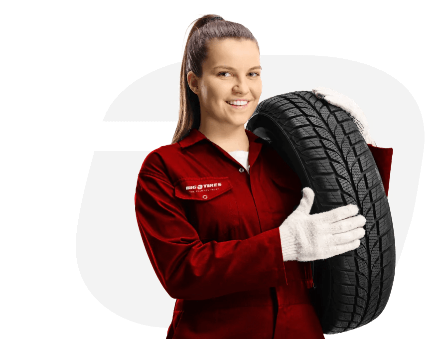 A woman holding a tire in front of a white background at an automotive franchise.